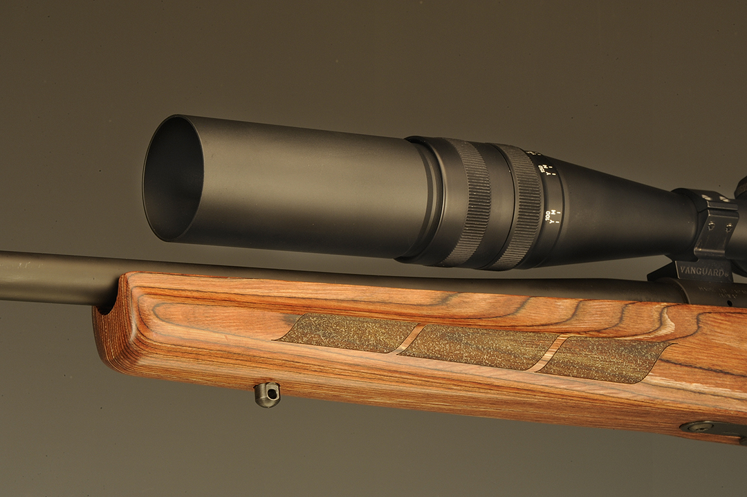 On this model of Vanguard, there is no traditional forend tip, but none is needed. The forearm is tapered from the tip to the magazine and the three-panel stippling is standard. The lens hood cuts down on the effects of the sun from the side, recommended especially on varmint rifles when out all day.